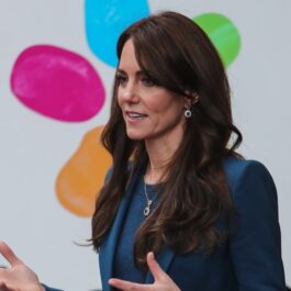 Kate Middleton într-un costum albastru în timp ce discută cu un public în timpul unui eveniment