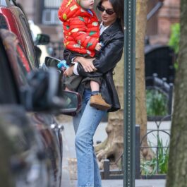 Emily, îmbrăcată casual, cu fiul ei în brațe