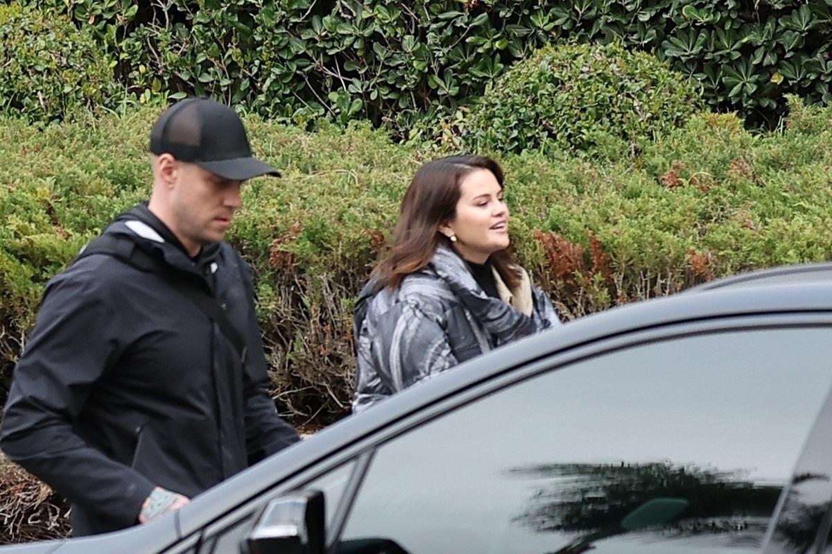 Selena Gomez în timp ce zâmbește și merge spre o mașină privată
