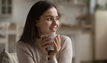O femeie fericită că bea o ceașcă cu cafea