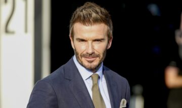 David Beckham în timp ce pozează îmbrăcat la costum la un eveniment de covor roșu