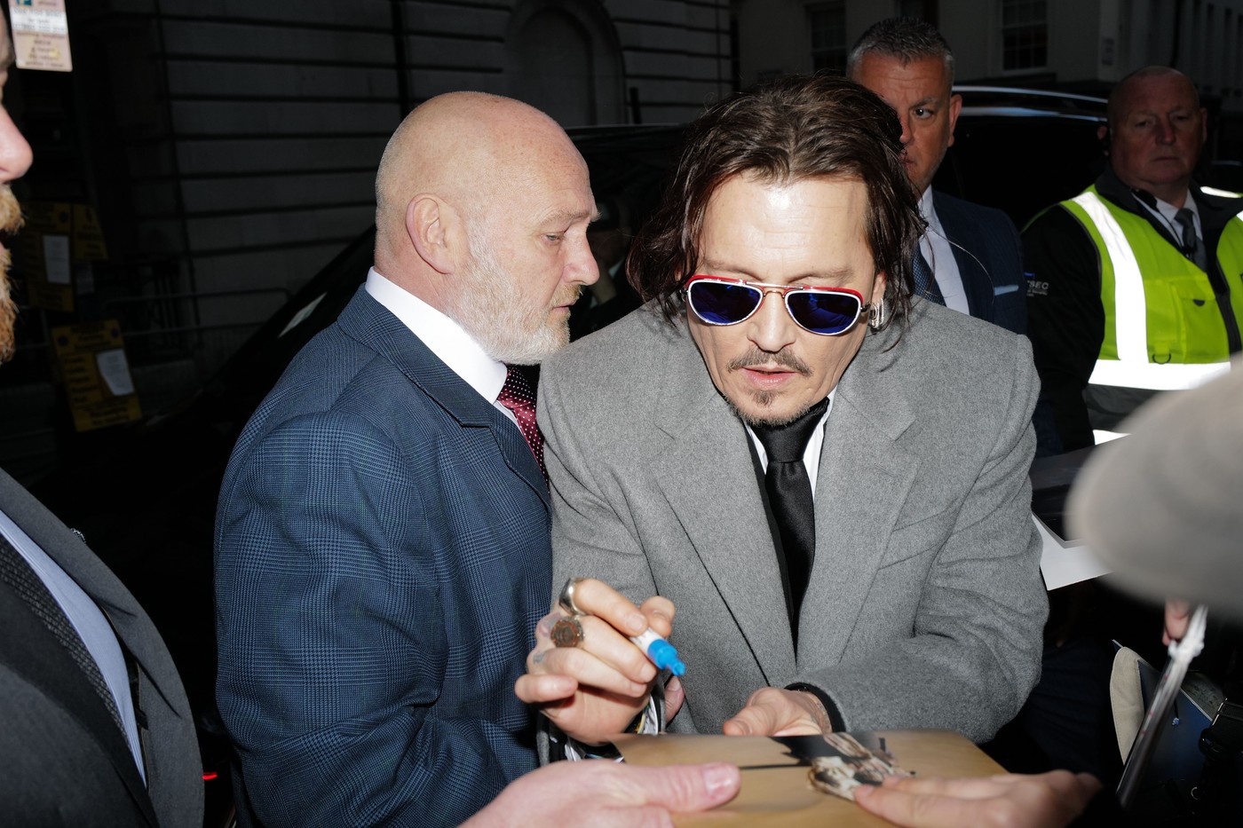 Johnny Depp la premiera filmului Jeanne Du Barry în timp ce semnează autografe