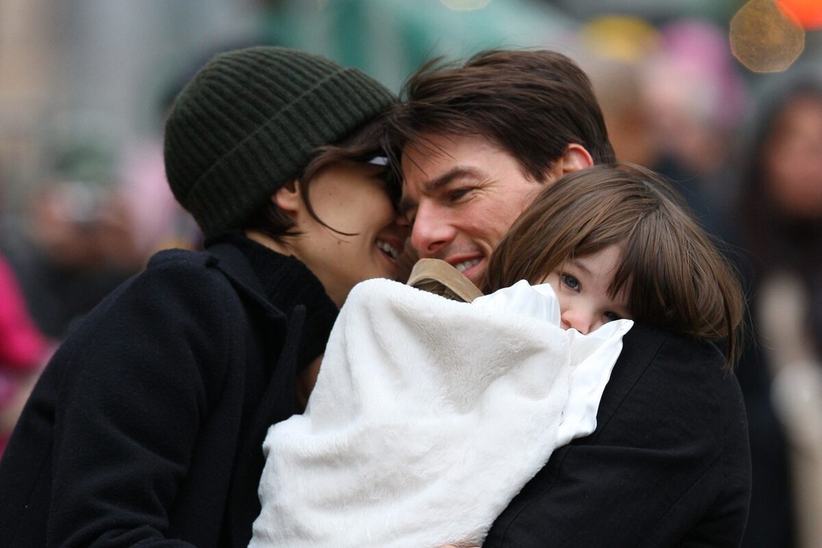 Katie Holmes și Tom Cruise în timp ce o țin pe Suri Cruise în brațe într-o imagine din 2008