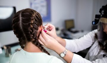 O femeie tânără care își verifică auzul la medic
