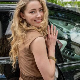 Amber Heard, zâmbitoare, în timp ce urcă în mașină