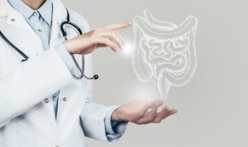 O doctoriță care arată cu mâinile spre o hologramă a intestinelor