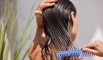 O femeie care își aplică ulei pe păr