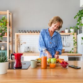 O femeie care are peste 50 de ani și prepară cu ajutorul legumelor meniuri pentru diete de slăbire