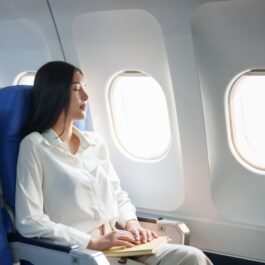 O femeie care doarme în timpul unei curse cu avionul