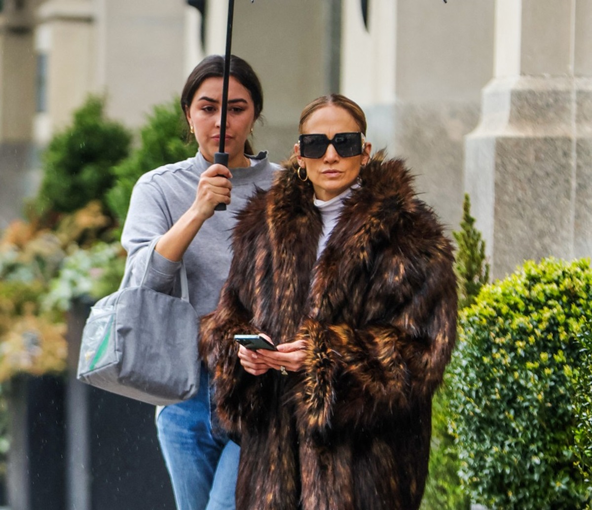 Jennifer Lopez într-o haină de blană în timp ce se plimbă pe străzile din New York, în timp ce asistenta ei îi ține deasupra capului o umbrelă