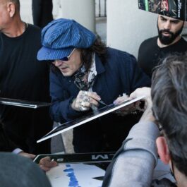 Johnny Depp în timp ce le oferă autografe fanilor săi din Statele Unite ale Americii