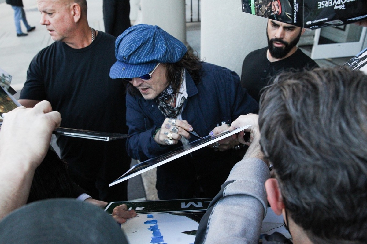 Johnny Depp în timp ce le oferă autografe fanilor săi din Statele Unite ale Americii