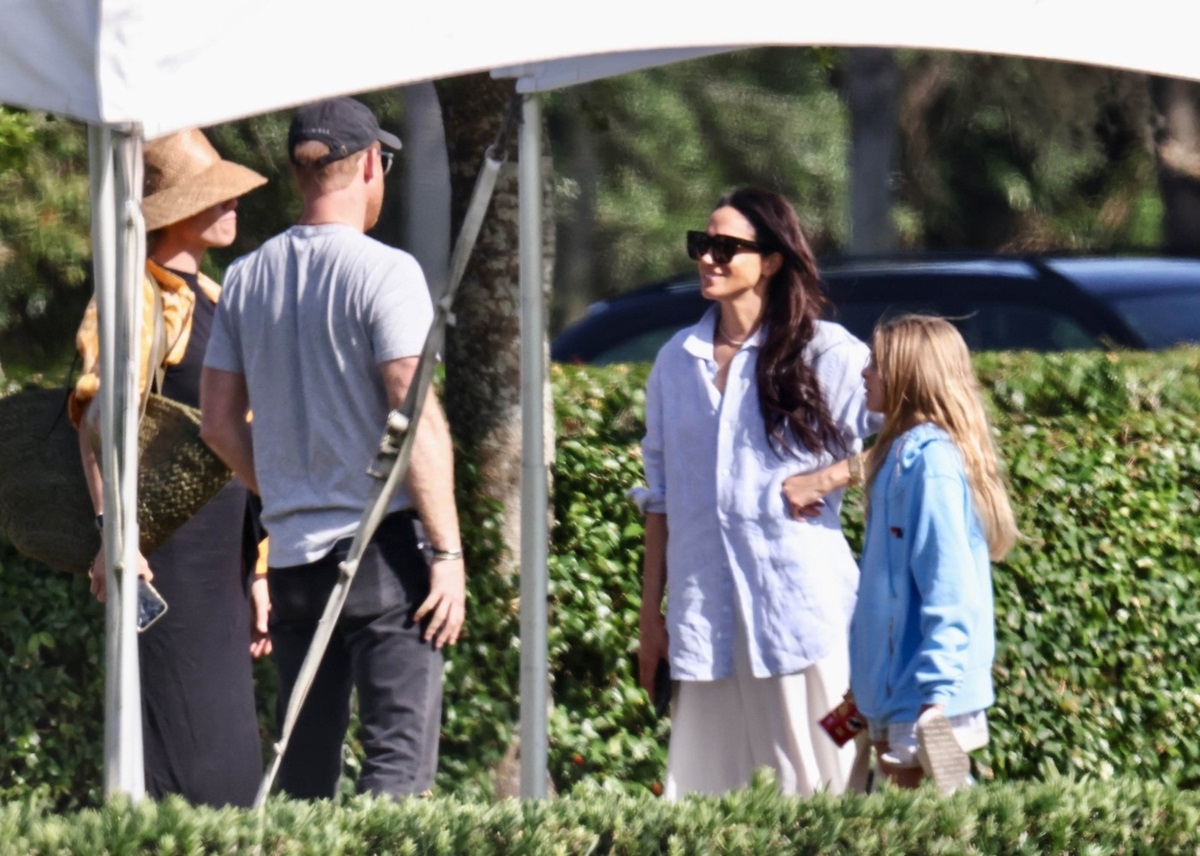 Meghan Markle în timp ce stă de vorbă cu Prințul Harry pe terenul unui meci de polo din Florida