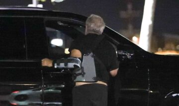 Mel Gibson în timp ce vorbește cu șoferul mașinii personale și este fotografiat de la spate