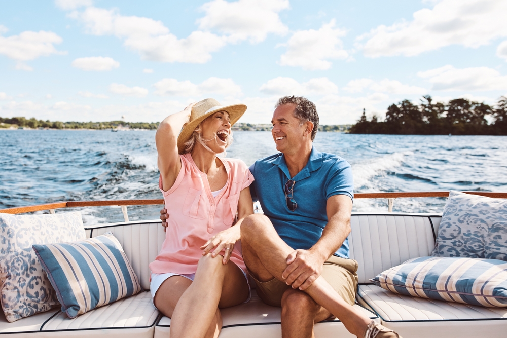 doi oameni îndrăgostiți care râd pe o barcă într-o zi însorită