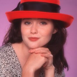Shannen Doherty, imagine din tinerețe, cu o pălărie roșie pe cap
