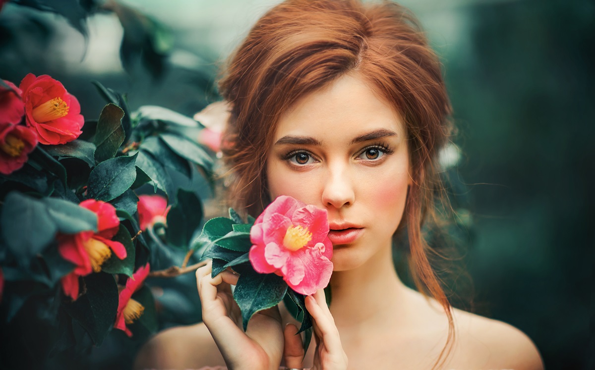 O femeie frumoasă care ține un trandafir alături de fața sa pentru a ilustra una dintre acele zodii pe care vei regreta dacă le vei pierde din viața ta