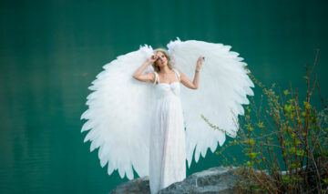 O femeie în rochie albă, cu aripi în spate