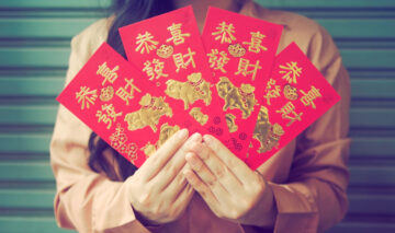 cartonașe cu simboluri chinezești ținute în mână de o femeie