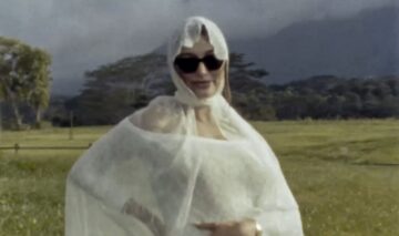 Hailey Bieber, într-o rochie albă din dantelă, cu mâna pe burtica de gravidă